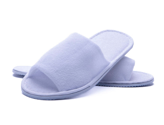 Witte wegwerp hotelslippers voor gasten op de hotelkamer