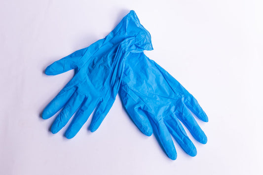 Blauwe wegwerphandschoenen op een witte ondergrond